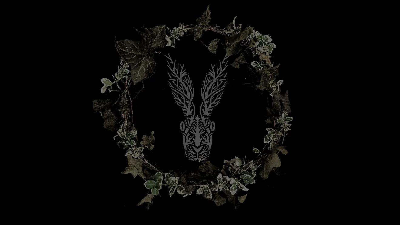A wreath of ivy and dark foliage surrounds a stylised stag mark on a black background — the emblem of Roads to Withered Hill